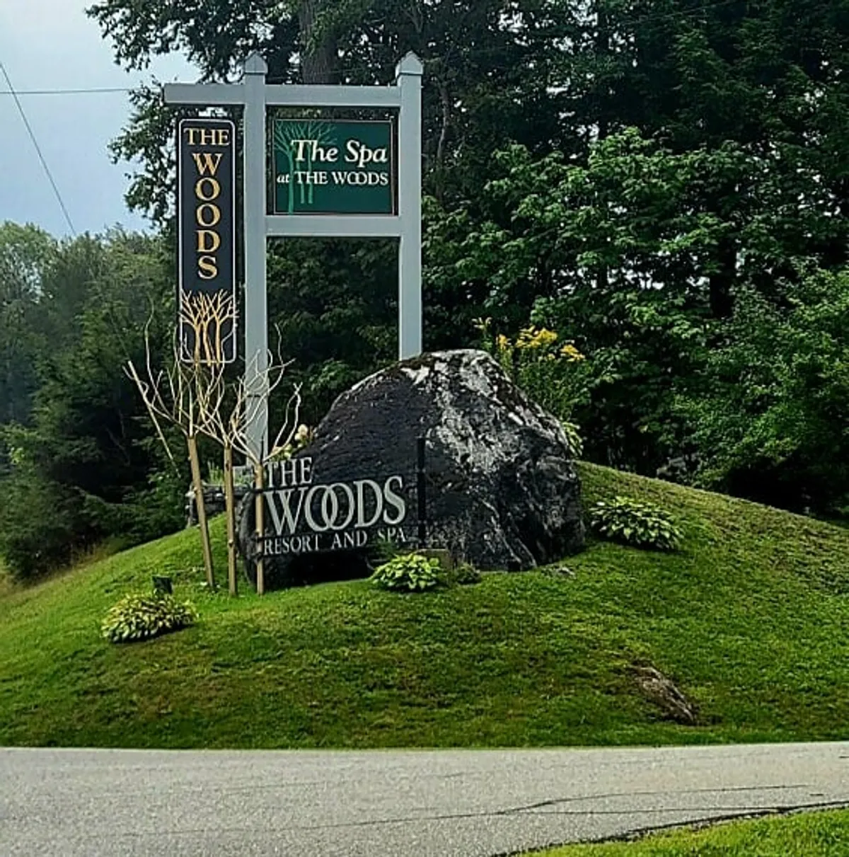This image features the signage for The Woods, nestled on a stone base and surrounded by lush greenery. The tranquil, nature-focused atmosphere is evident, suggesting a welcoming entrance to the retreat and highlighting the connection between the spa facilities and the natural Vermont setting.